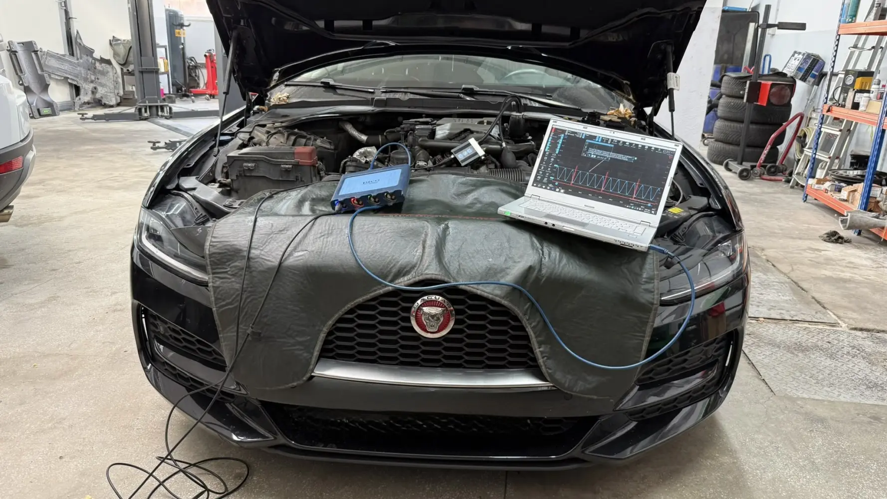 Jaguar XE cu capota ridicată în atelier, și cu PicoScope conectat