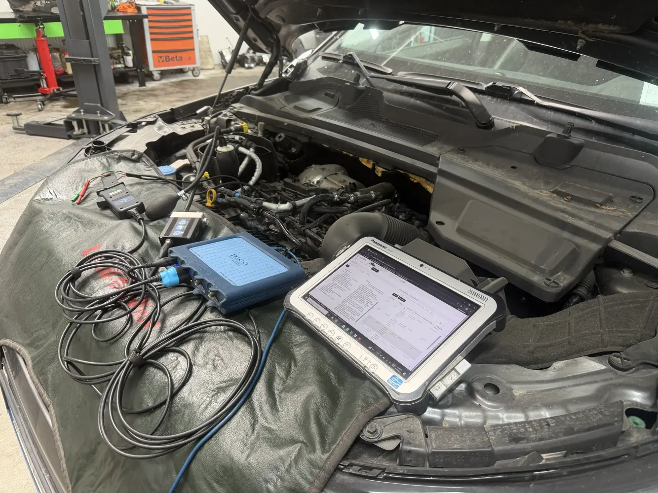 Tabletă cu TOPIx Cloud și PicoScope conectate la un motor JLR