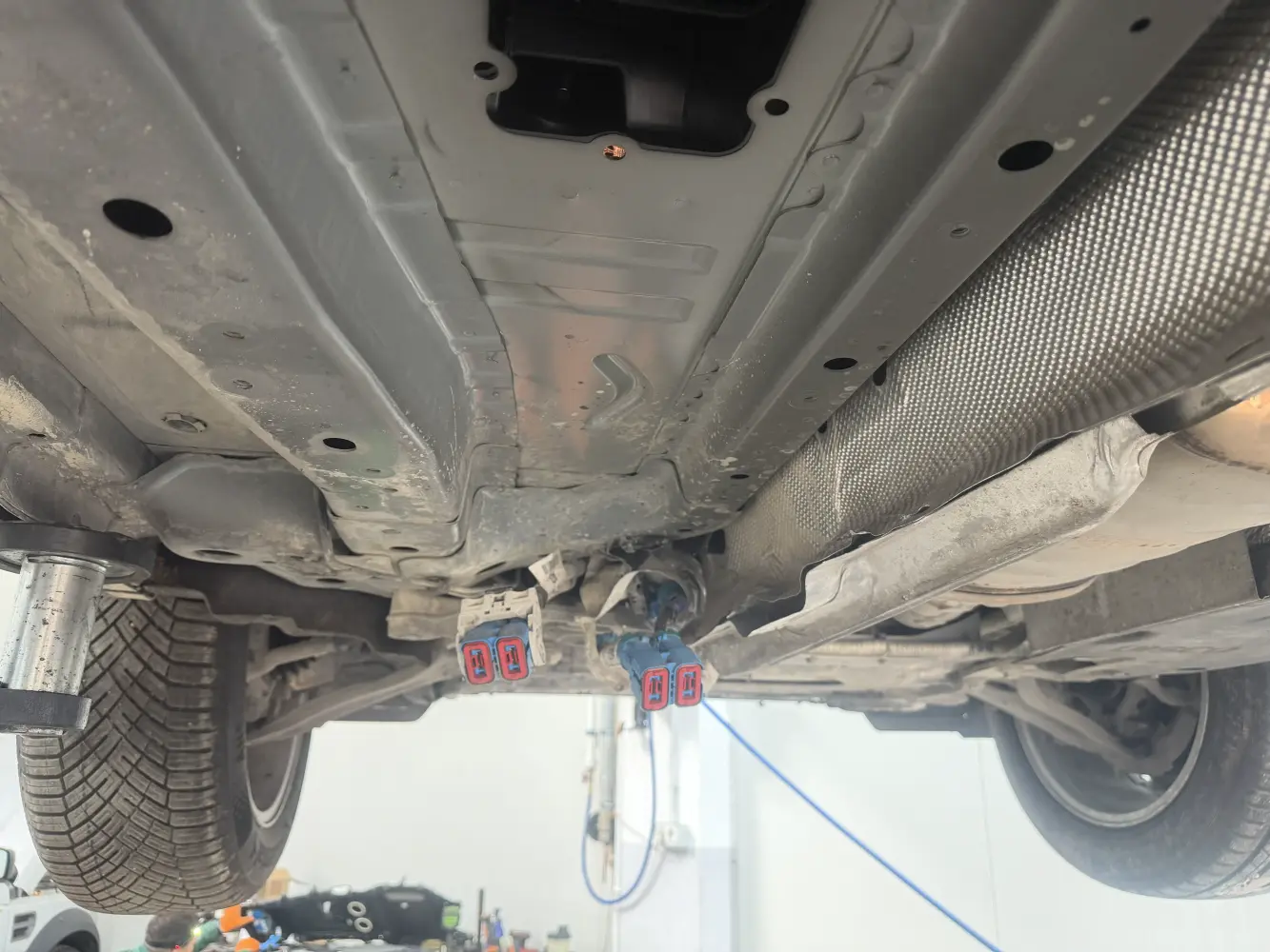 Partea inferioară a vehiculului după coborârea ansamblului, cu conectorii de înaltă tensiune decuplați